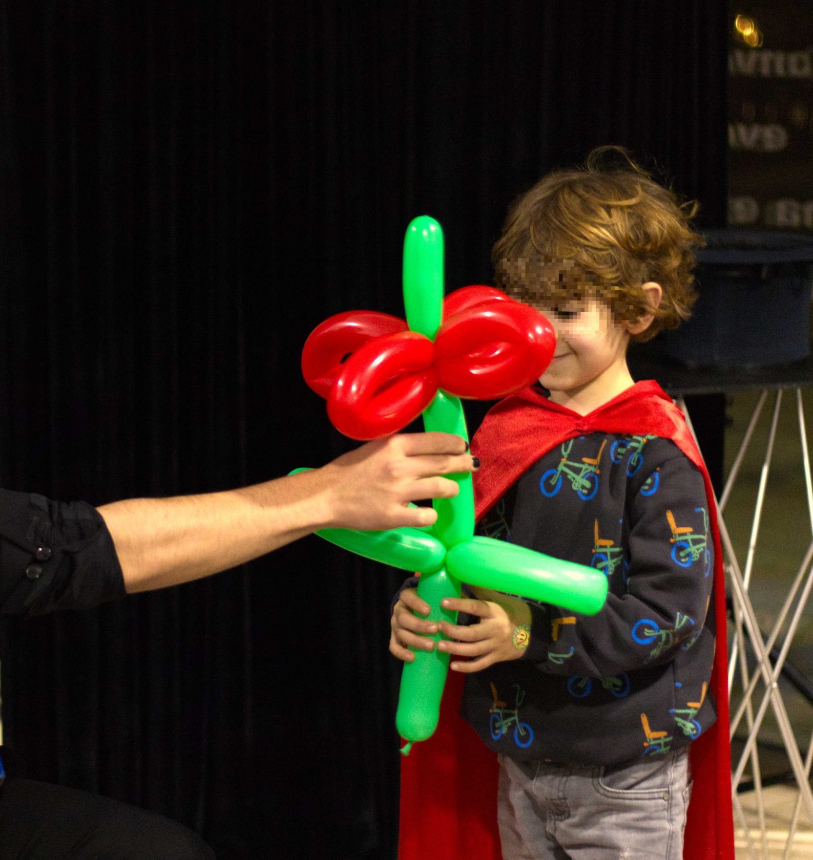 Foto de un niño recibiendo una flor hecha con globoflexia